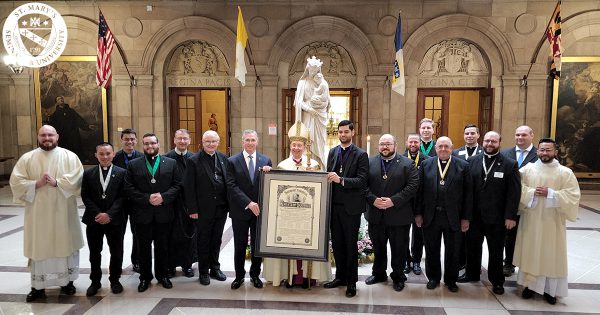 Blessed Michael McGivney Knights of Columbus Council members pose with Archbishop Lori, Patrick Kelly, and the new charter in front of the Sedes Sapientiae statue.
