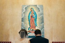 Newly married couple prays before Our Lady of Guadalupe