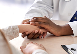 Image of hospice/palliative care professional comforting patient.