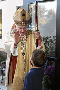 One of the youngest members of the faithful high-fives Bishop Zubik after Mass.