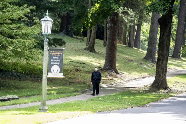 A man walking down a sidewalk at St Mary's.